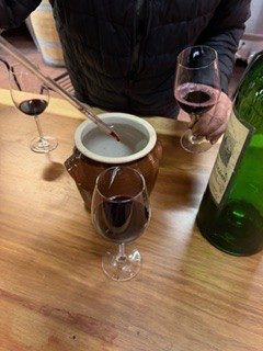 Drawing a barrel sample with a pipette during a cellar tasting