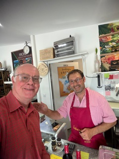 Brian with a local wine merchant in his shop in France